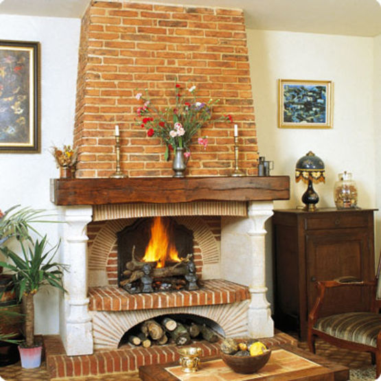 cheminée en briques rouges avec du bois de chauffage et un panier