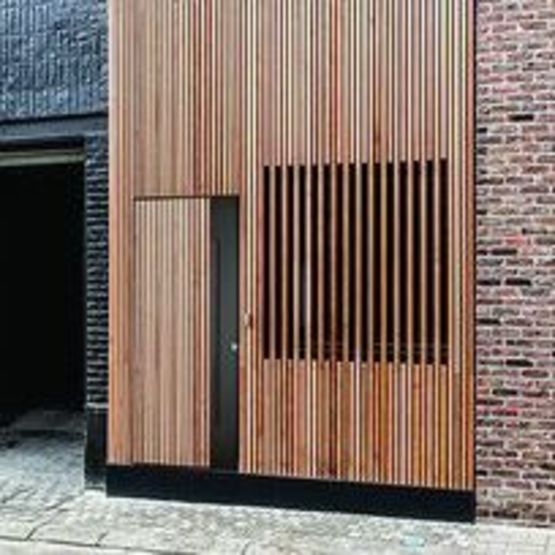 Porte en bardage vertical à claire-voie pour maison ossature bois | Open Nature